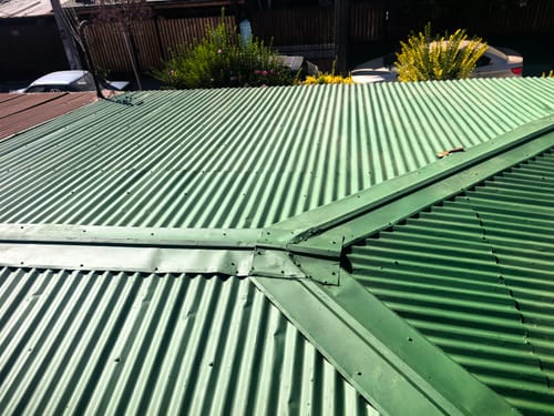 Un cliente muestra la unión de su techo corrugado pintado con el sellador verde Lanco Coolguard.