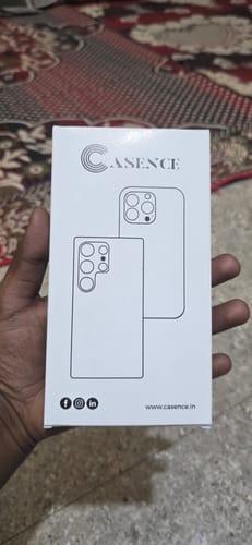 Reviewer holding the white retail box for the Anti Yellow Magsafe Clear Case.