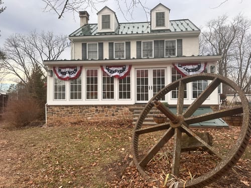 Customer's house decorated with several patriotic Betsy Ross style buntings hanging along the porch.