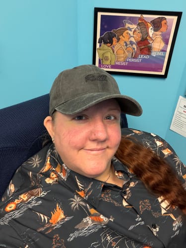 Reviewer smiling while wearing the dark Days of Plunder shirt, showing off its detailed pirate-themed pattern.