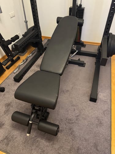 Ein Kunde zeigt die stabile, schwarze B6 Hantelbank in seinem Trainingsbereich.