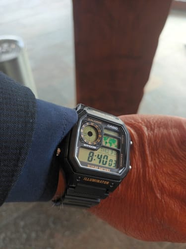 Cliente mostrando su reloj Casio World Time Royale negro en la muñeca.
