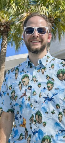 A reviewer outdoors wearing the Avatar 'Hallelujah Mountains' KUNUFLEX Short Sleeve Shirt.