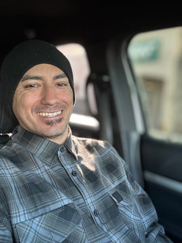 Customer smiling while wearing the gray and black plaid Burn Out Flannel.