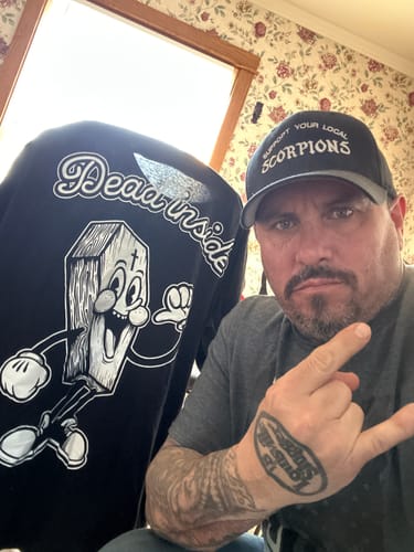 Customer showing the back of the black "Dead Inside" t-shirt with its large cartoon coffin graphic.