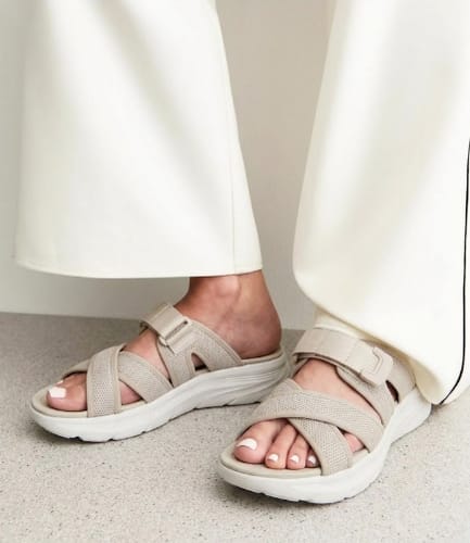 Customer wearing beige Haloproduct sandals with thick white soles and adjustable crisscross straps.