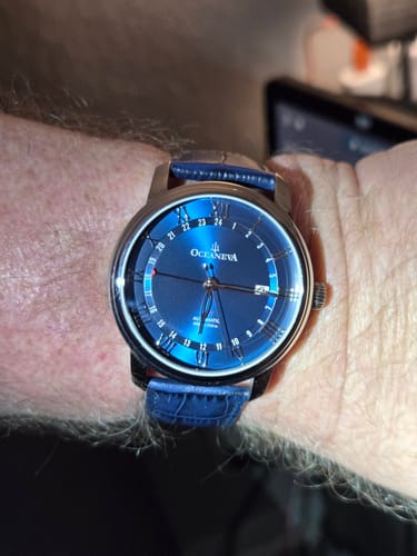 Reviewer's Oceaneva OceanTrek GMT watch with a vibrant blue dial shown on their wrist.
