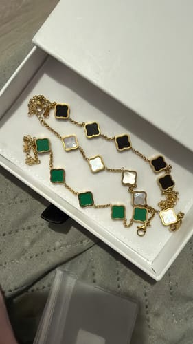 Reviewer's three Celine Clover Bracelets with green, white, and black motifs displayed inside a white box.