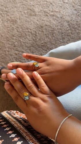 Customer's and sister's hands showing their matching Navae Birthstone Rings in gold and silver tones.