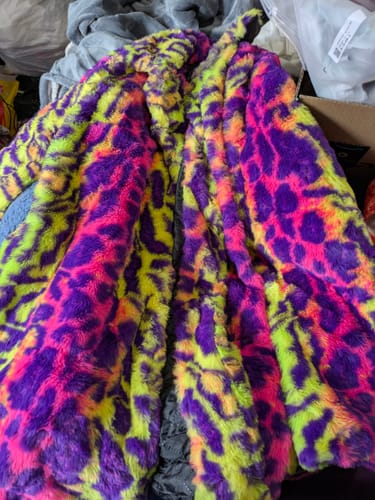 Close-up of the customer's colorful faux fur leopard overcoat showing its plush texture and vibrant pattern.
