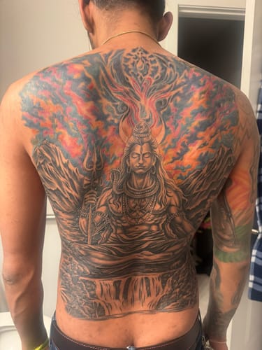 Reviewer's back showing a large, detailed tattoo of Shiva done using the Painless Tattoo Numbing Cream.