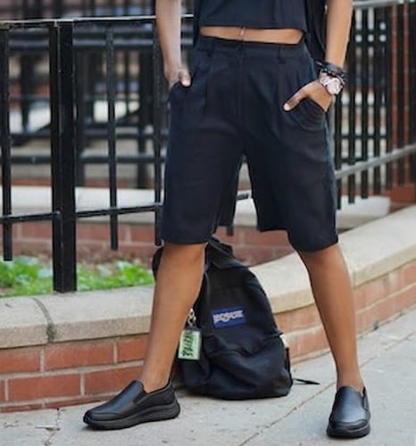 Reviewer standing on a sidewalk wearing black, slip-on Dry Fit shoes.