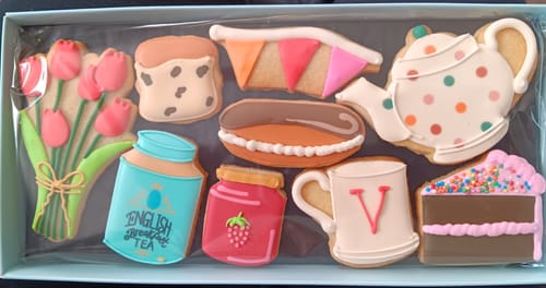 Reviewer shows the Mother's Day Tea Deluxe Biscuit Box with detailed, iced biscuits shaped like a teapot, cake, and flowers.