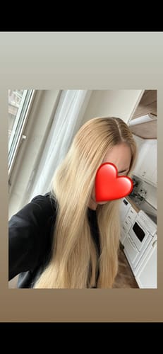 Customer shows their long, golden blonde hair after using the Sunkissed Starter Kit.