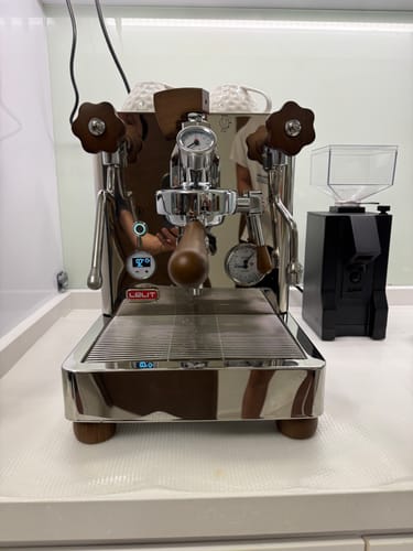 Customer's photo of a shiny stainless steel espresso machine with wood accents from their showroom appointment.