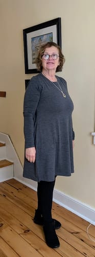 Reviewer wearing the Clara Dress in Cinder Melange with a matching shirt for a long-sleeved look over black leggings.