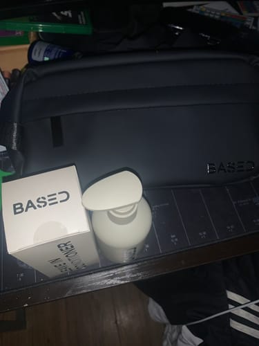 Customer's Based Bodyworks Leave-in Conditioner in a white pump bottle, shown with its box on a desk.