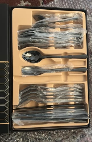 Reviewer's new 24-piece black cutlery set displayed inside its original packaging.