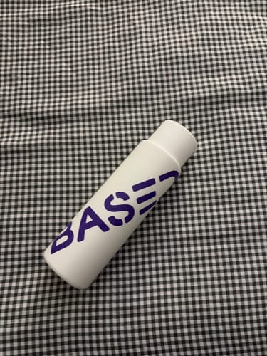 Reviewer's white conditioner bottle with purple lettering lying on a checkered surface.