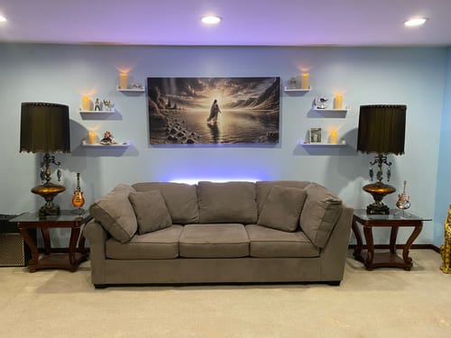 Customer's 'Walking on Water' faith wall art hung centrally over a sofa in a living room.