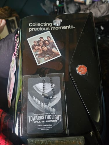 Customer's ATEEZ PLAYCODE gift, showing the black collector album with a group photocard and tour pass displayed.