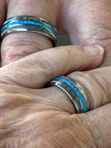 Close-up of two customers' hands, each wearing a silver Vanguard ring with a bright blue opal inlay.