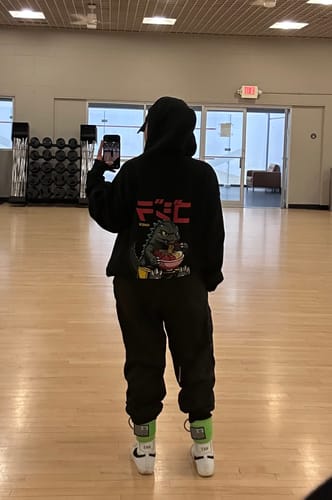 Reviewer from behind showing the graphic on their oversized black RAMEN MONSTER HOODIE in a mirror selfie.
