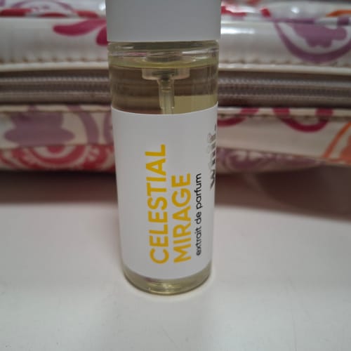 Close-up of a reviewer's Celestial Mirage perfume bottle on a white surface.