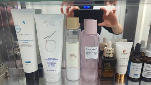 Reviewer's SkinCeuticals Micro-Exfoliating Scrub on a shelf with other skincare products.