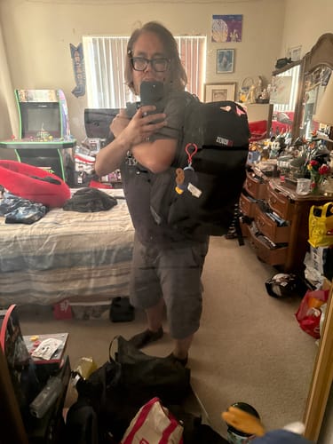 Reviewer wearing the RSVLTS Black Backpack V1 in a mirror selfie.