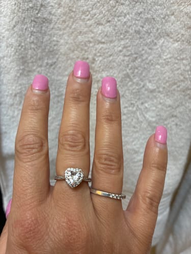 A reviewer's hand wearing the silver-toned, heart-shaped Forever In My Heart Urn Ring.