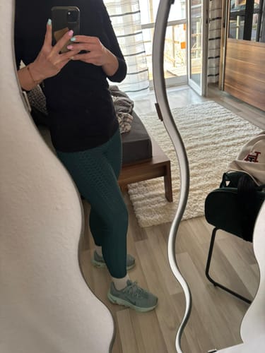 Rezensentin in einer Spiegelaufnahme in den blaugrünen, strukturierten Classic Anti-Cellulite Leggings.