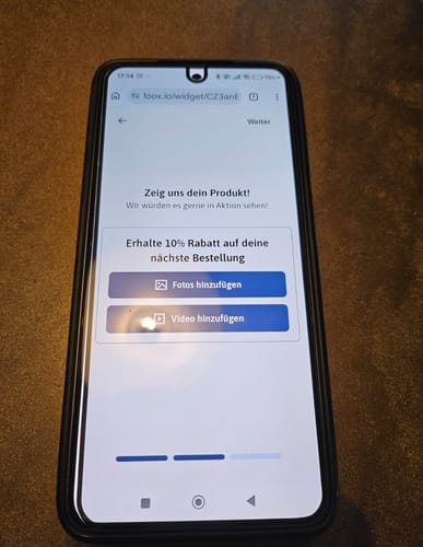 Ein Rezensent zeigt die 3-in-1-Schutzfolie, die außermittig auf einem Xiaomi-Smartphone aufgebracht ist.