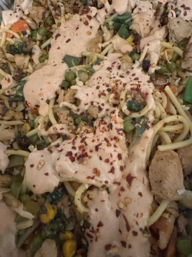 Reviewer's prepared dish of Halal Chicken Leg & Thigh cut up with noodles, vegetables, and a creamy sauce topped with red pepper.