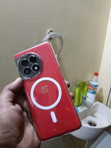 A customer holds their red OnePlus 11R phone in the clear Magsafe case, showing the white magnetic ring on the back.