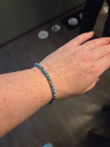 Reviewer's wrist wearing the Turquoise Pulse Bracelet, showing the turquoise beads and silver-tone rings.
