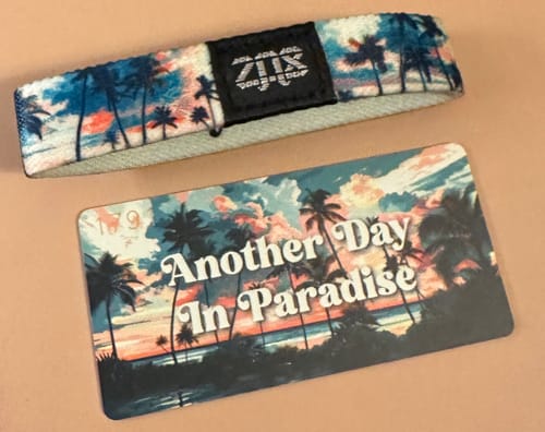 Customer's Another Day In Paradise Bracelet and its matching collector card, both featuring a sunset and palm tree design.