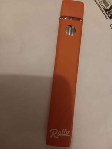 Customer's orange ROLLZ THCA Vape shown unboxed and lying on a flat white surface.
