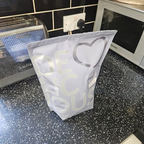 Customer's light purple pouch of Delicious Protein Shake sitting on a kitchen counter.