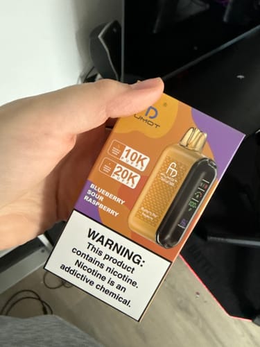 Customer holding the packaging for the Randm Tornado 20000 vape, showing the Blueberry Sour Raspberry flavor.