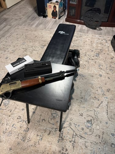 Customer's Site Right Boresighter in its open case next to a lever-action rifle on a small table.