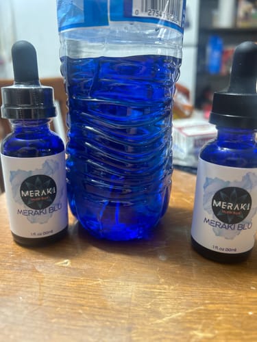 Customer's two bottles of Meraki Blu Methylene Blue next to a water bottle containing the vibrant blue liquid.