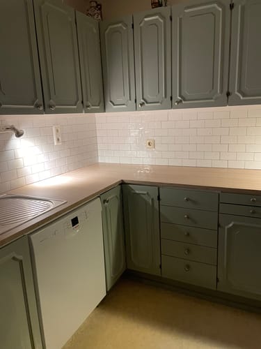 Kundens kjøkken med de nye, selvklebende hvite subway-flisene montert som en opplyst bakvegg.