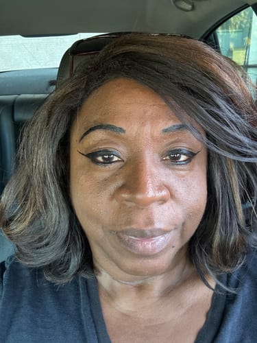 Reviewer in a close-up photo showing the full, wavy texture of their Shake N Go NYAH wig.