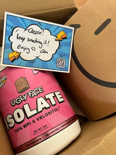 Reviewer's pink UGLYFACE ISOLATE PROTEIN tub inside a delivery box with a personalized card.