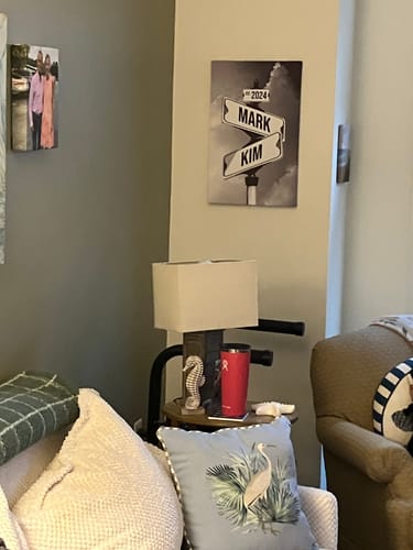 Customer's personalized street sign canvas with the names 'Mark' and 'Kim' and the year '2024' hanging on a living room wall.