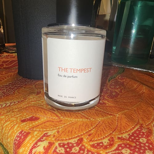 Customer's bottle of The Tempest Eau de Parfum resting on a patterned orange tablecloth.