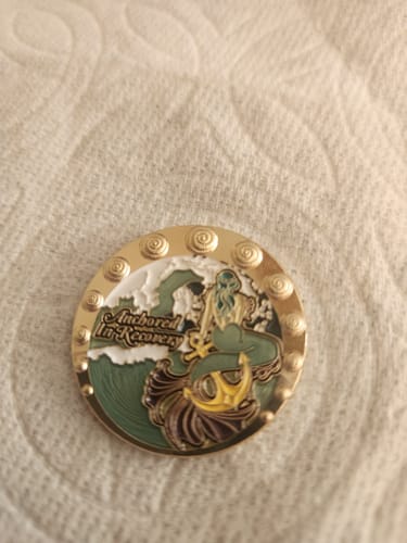 A customer's Anchored in Recovery medallion with a detailed aqua mermaid and gold anchor design.