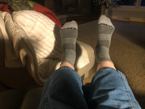 Reviewer's feet up while relaxing in the striped grey Quarter Socks.