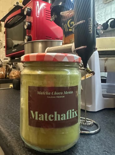 Cliente muestra un frasco de Té Matcha Premium Choco-Menta sobre la encimera de una cocina.